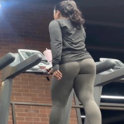 Latina sexy com coxas grossas em leggings cinza justas na esteira