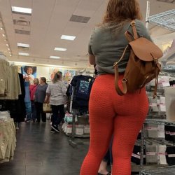 Incrível bunda gorda em leggings vermelhas na loja de roupas